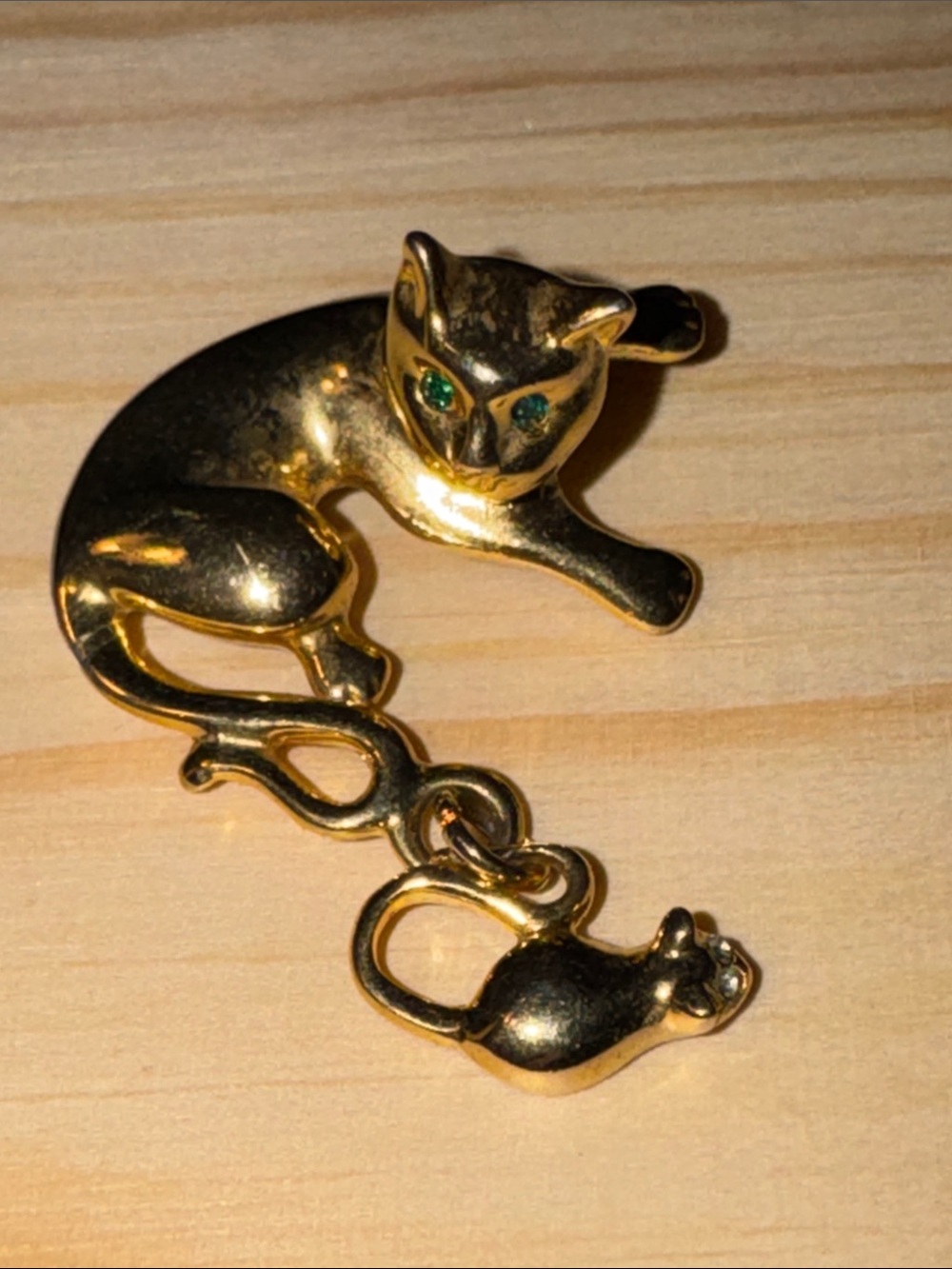 Vintage gold-tone metal cat brooch with green rhinestone eyes and a mouse